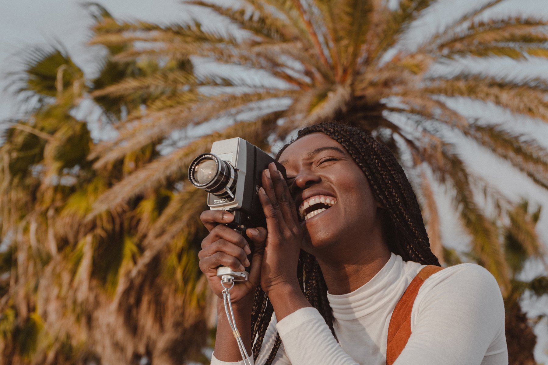 Happy Woman Using a Vintage Film Camera Outdoors