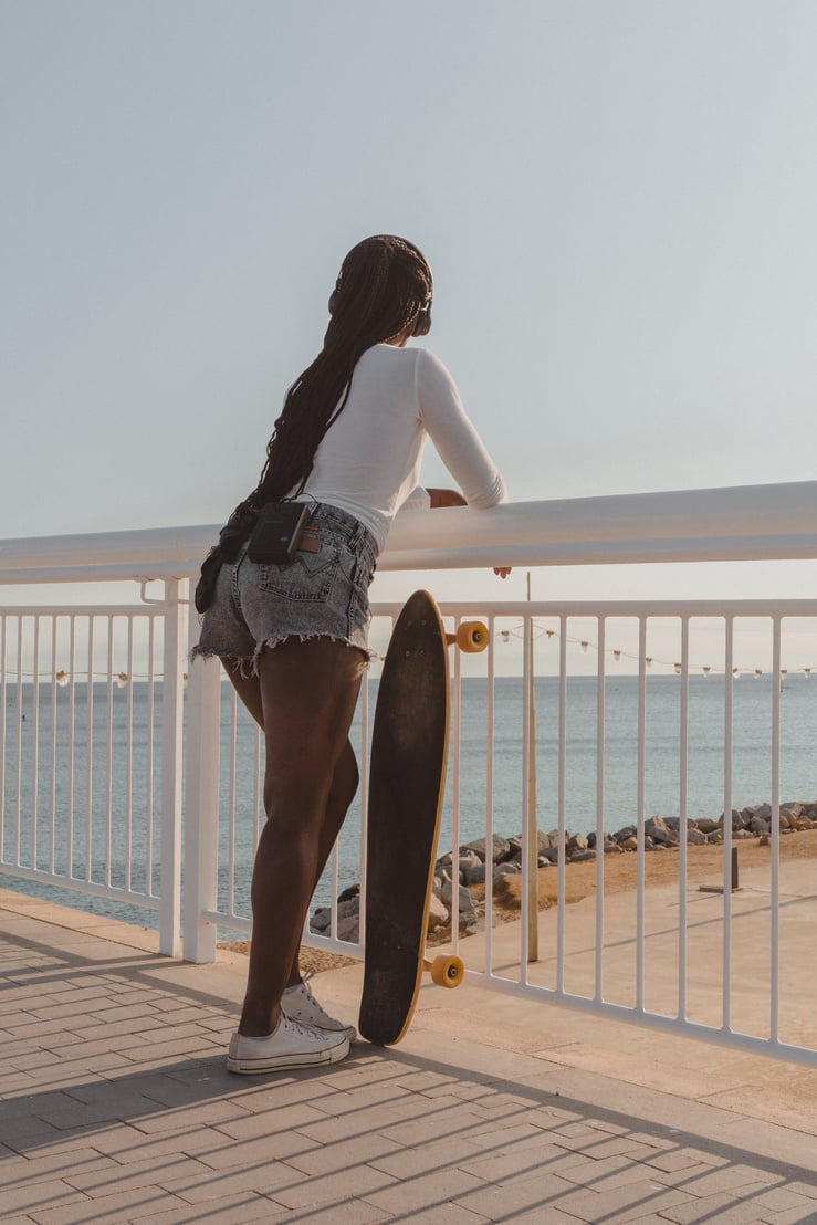 Woman with Longboard Listening to Music by the Sea